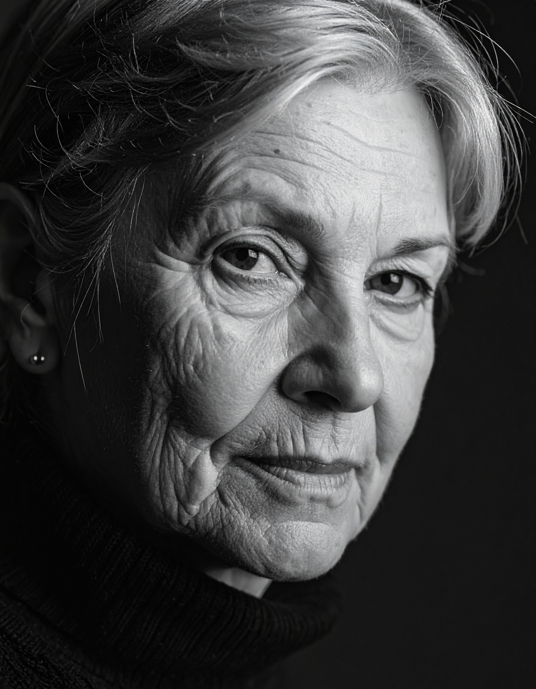 A striking black and white portrait of an older woman with a pensive expression