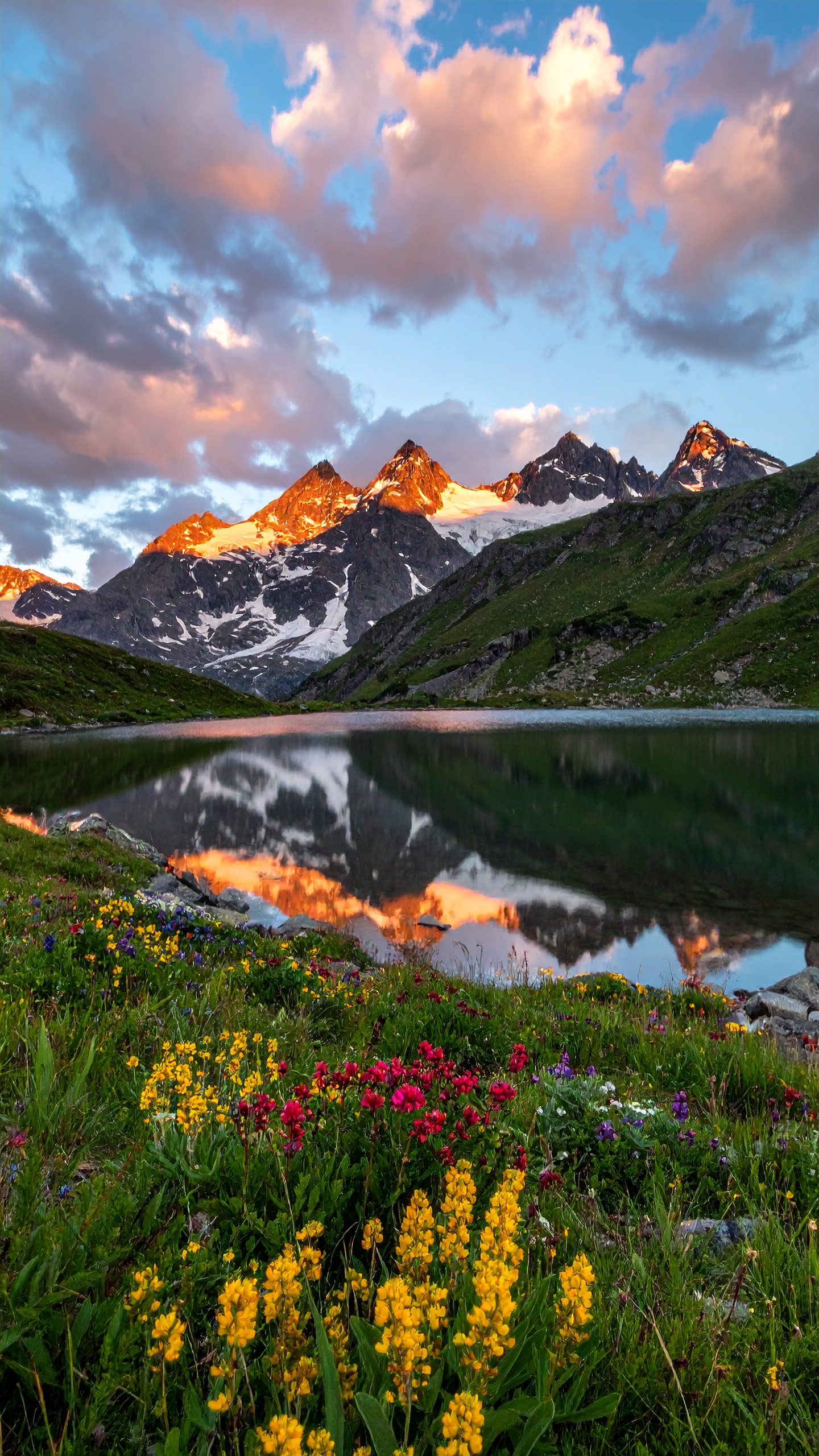 A stunning alpine landscape with snow-capped mountains reflecting in a serene lake