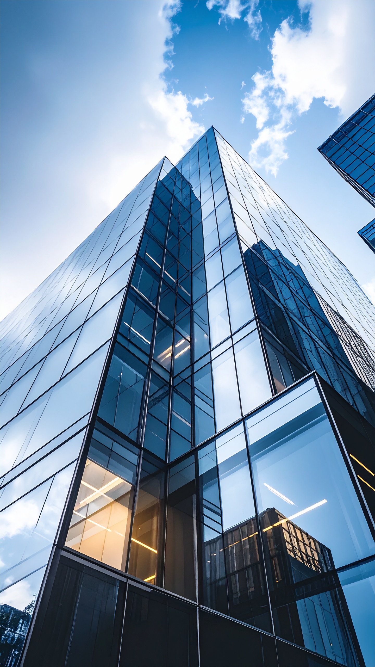 Modern Skyscraper with Glass Facade Reflecting Blue Sky