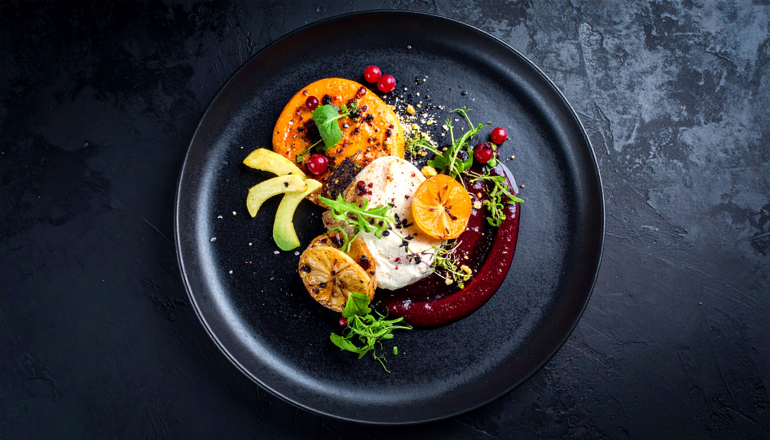 A gourmet dish elegantly presented on a dark plate