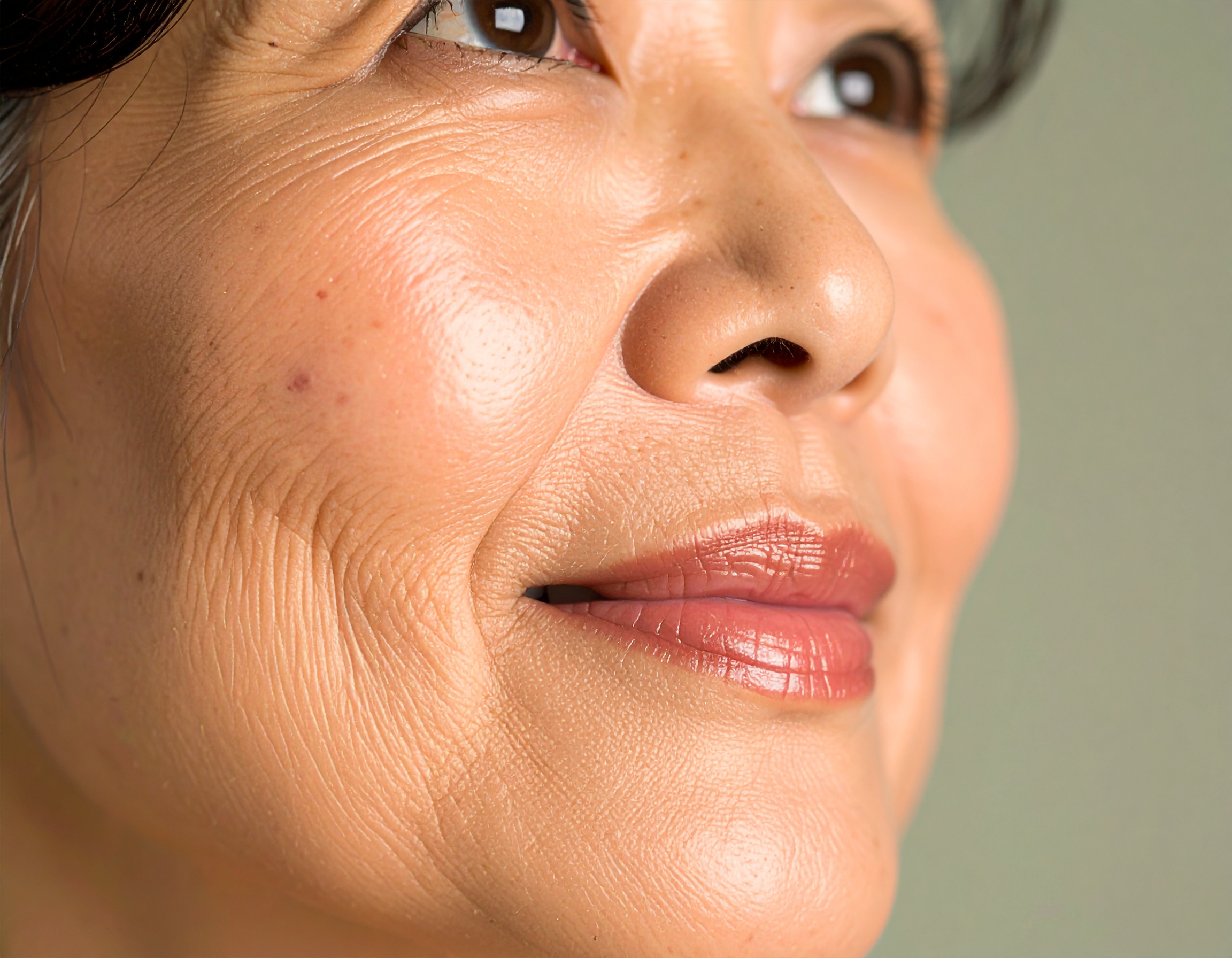 A close-up of a mature woman's face highlights natural skin texture and features
