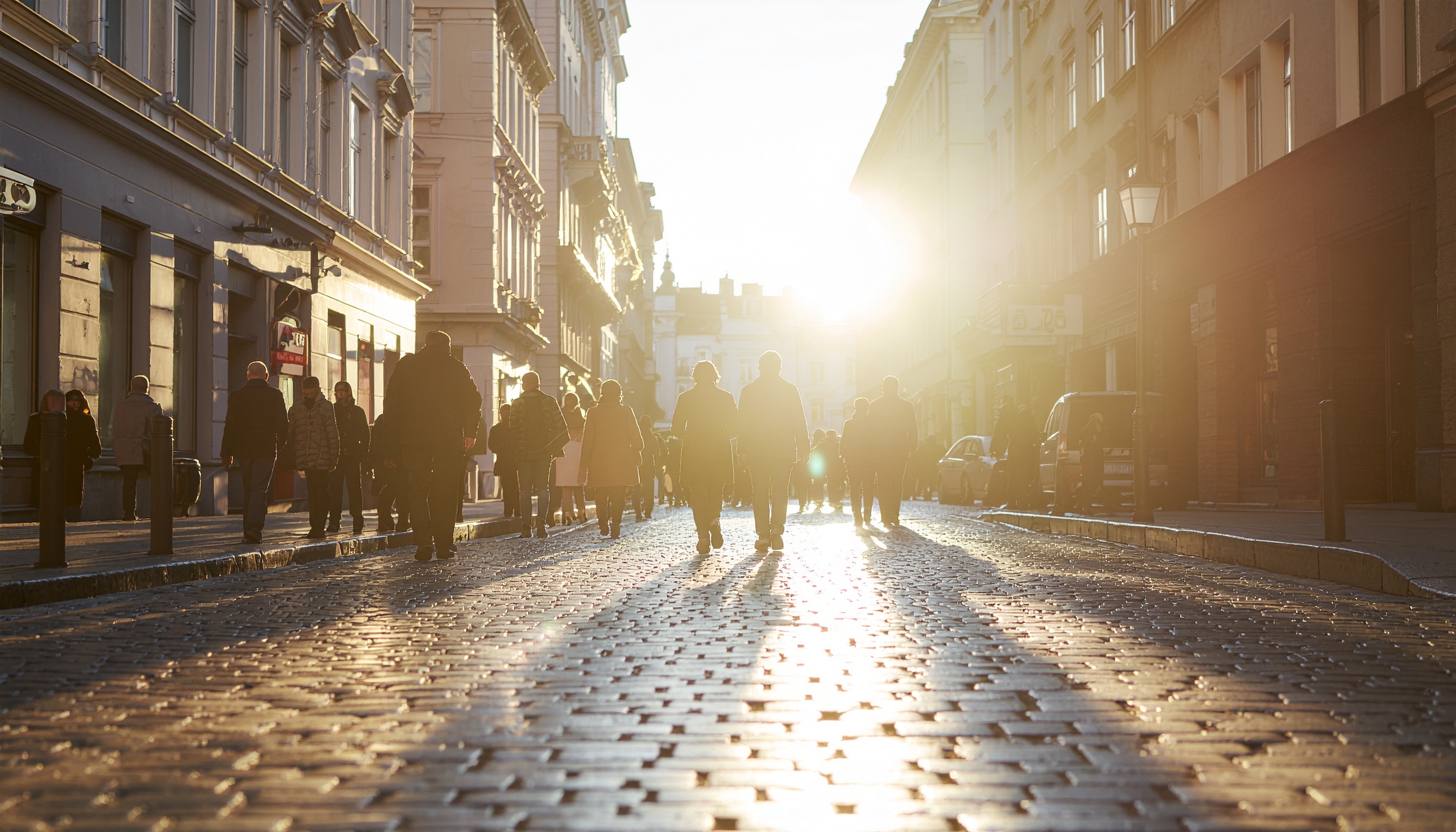 A bustling urban street scene with sunlight streaming through the buildings