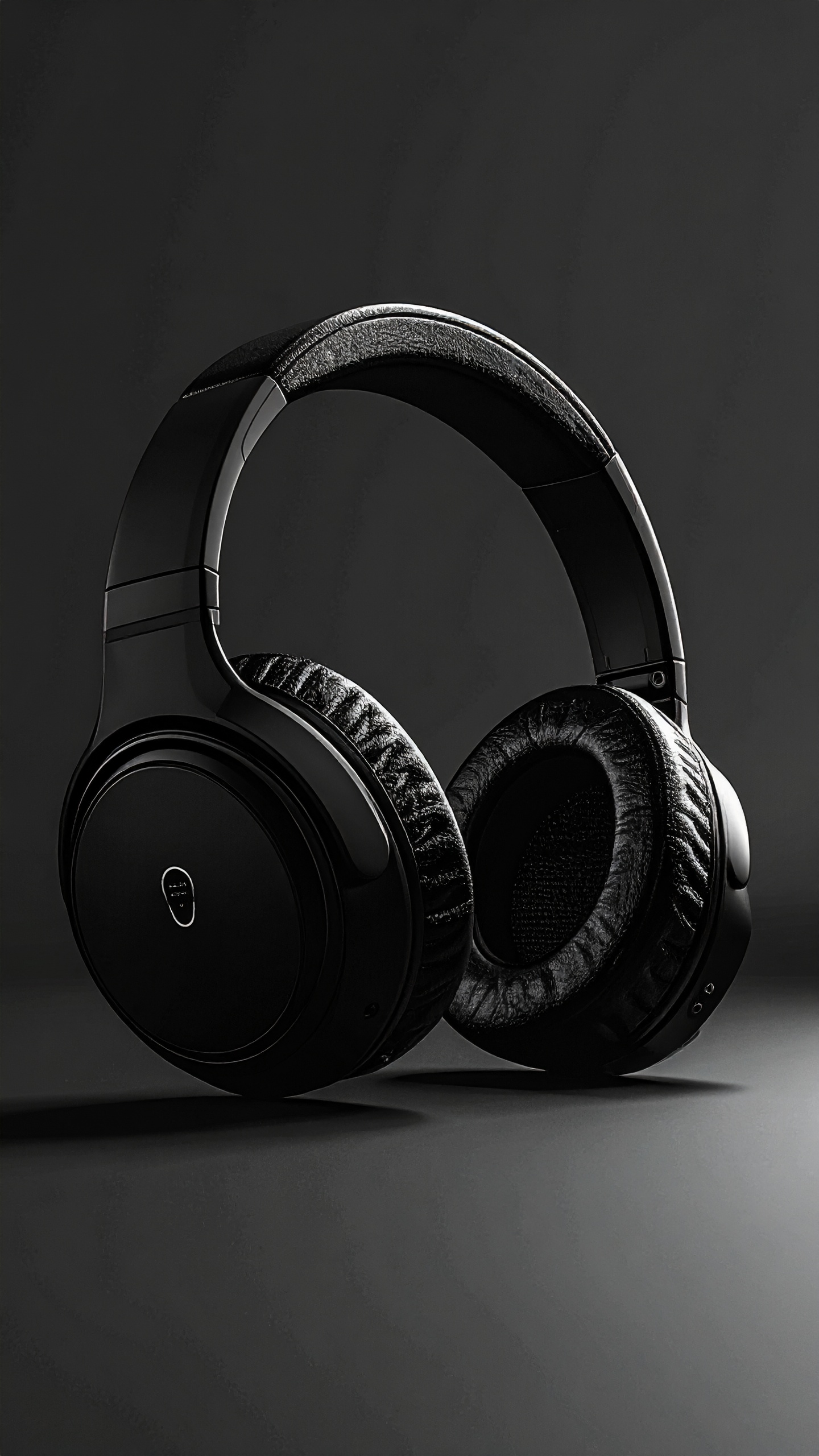 Fones de ouvido over-ear pretos em fundo escuro, com design elegante e acabamento brilhante. Iluminação suave destaca texturas acolchoadas e detalhes metálicos, criando uma atmosfera sofisticada e moderna.