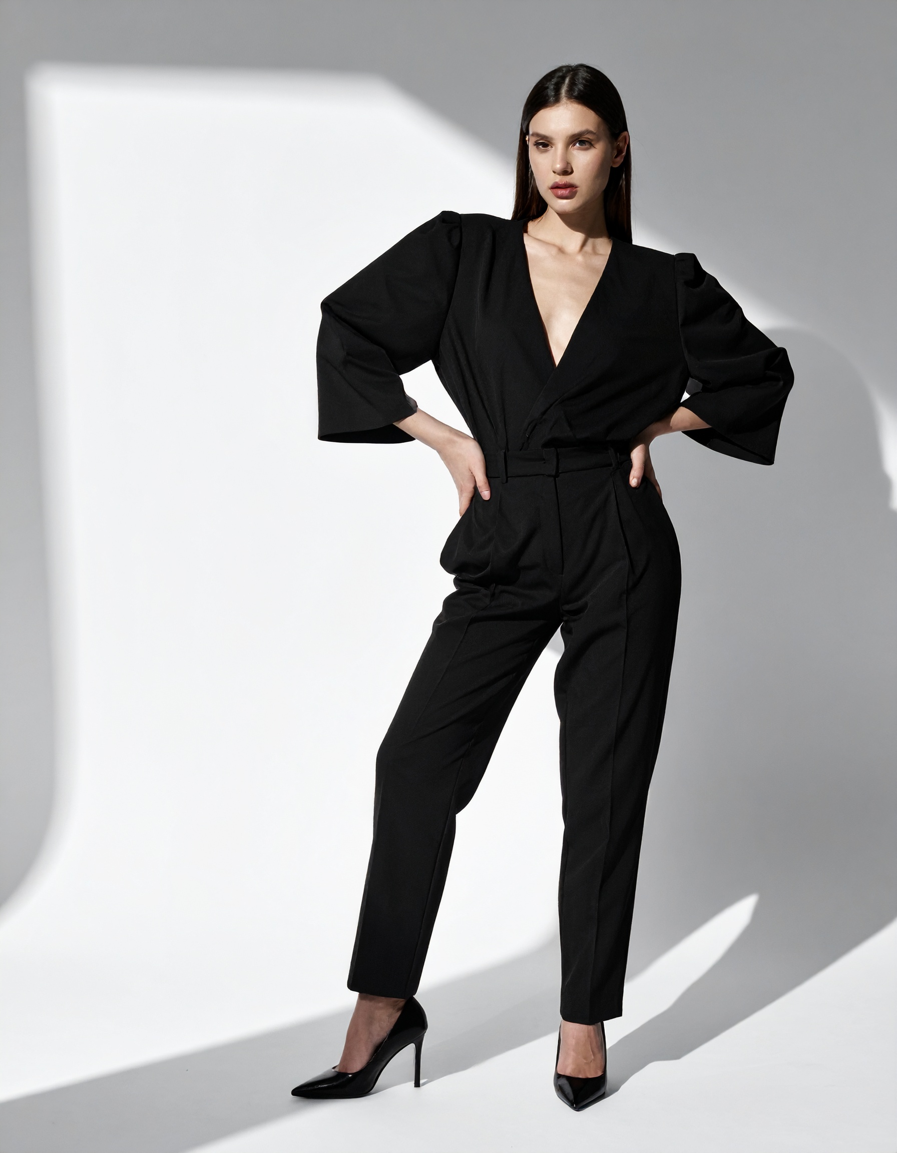 A sleek black jumpsuit with a deep V-neckline showcases elegance and style